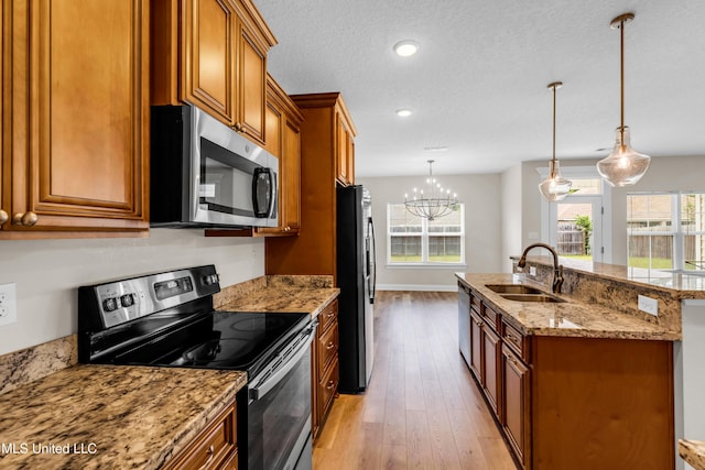 14864 Audubon Lake Blvd, Gulfport, MS 39503 - kitchen featuring stainless steel appliances, brown cabinets, an island with sink, healthy amount of natural light, and recessed lighting