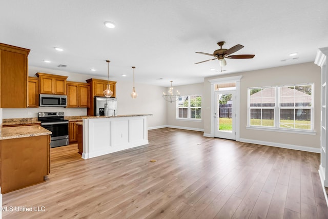 14864 Audubon Lake Blvd, Gulfport, MS 39503 - kitchen with stainless steel appliances, brown cabinetry, a chandelier, ceiling fan, and open floor plan