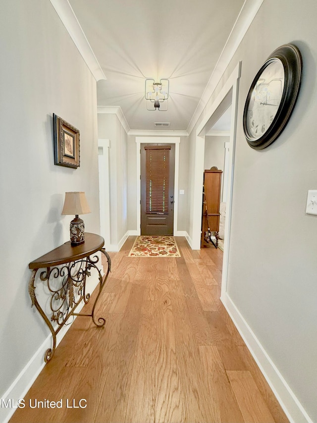 hallway featuring crown molding and light wood-type flooring