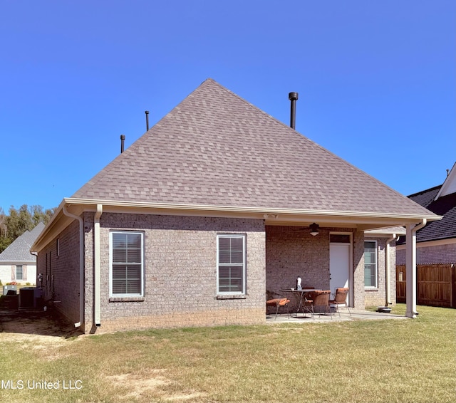 back of property featuring ceiling fan, a patio, and a lawn