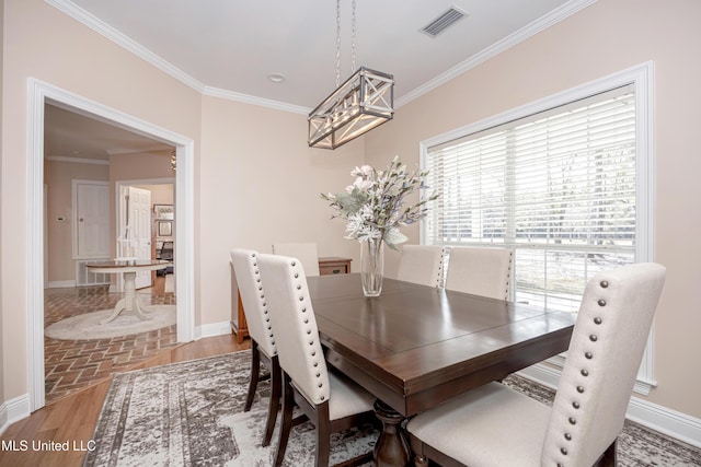 dining area featuring a notable chandelier, crown molding, and hardwood / wood-style flooring