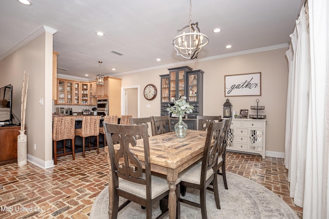 dining space with ornamental molding and a notable chandelier