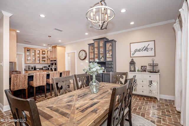 dining area with a chandelier and crown molding