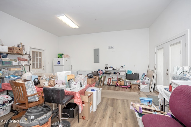 miscellaneous room with electric panel and light hardwood / wood-style flooring