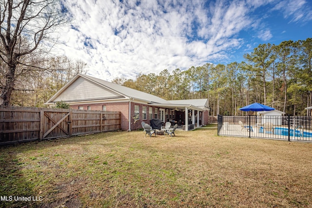 view of yard featuring a fire pit, a fenced in pool, and a patio area