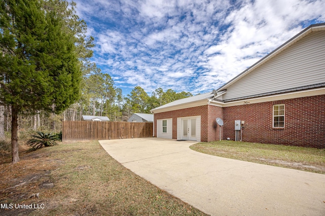 view of home's exterior featuring french doors, a patio area, and a lawn