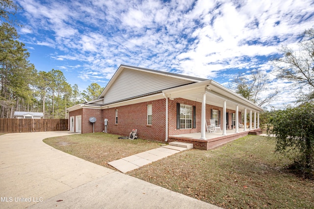 view of side of home featuring a yard and a porch