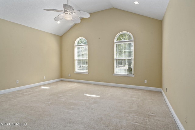 carpeted empty room featuring a wealth of natural light, lofted ceiling, and ceiling fan