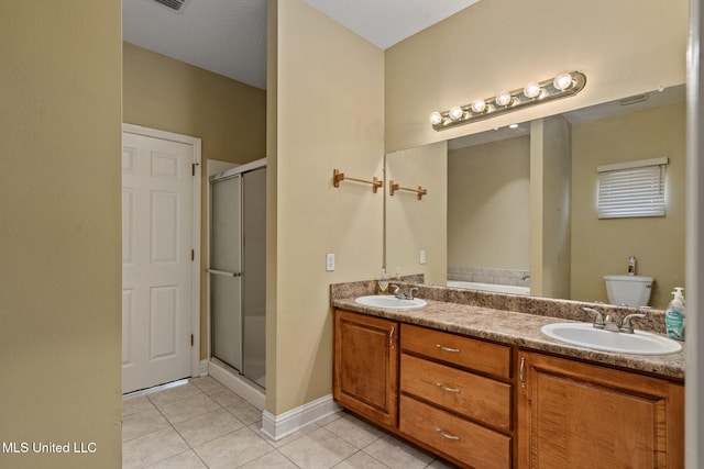 bathroom with vanity, tile patterned flooring, toilet, and walk in shower