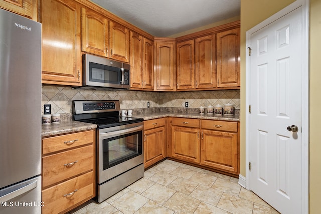 kitchen with tasteful backsplash, appliances with stainless steel finishes, and a textured ceiling