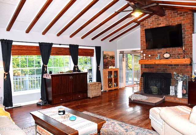 living room with a ceiling fan, a brick fireplace, wood finished floors, baseboards, and vaulted ceiling with beams