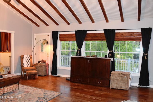 sitting room with baseboards, lofted ceiling with beams, dark wood finished floors, and a wealth of natural light
