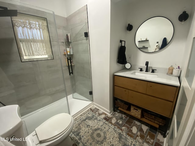 full bathroom with vanity, baseboards, a shower stall, and toilet