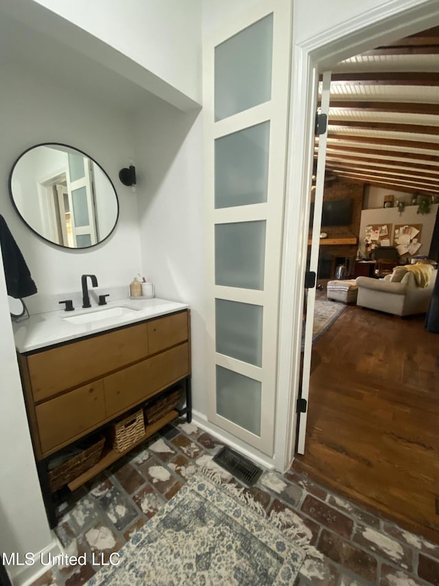 bathroom with brick floor and vanity