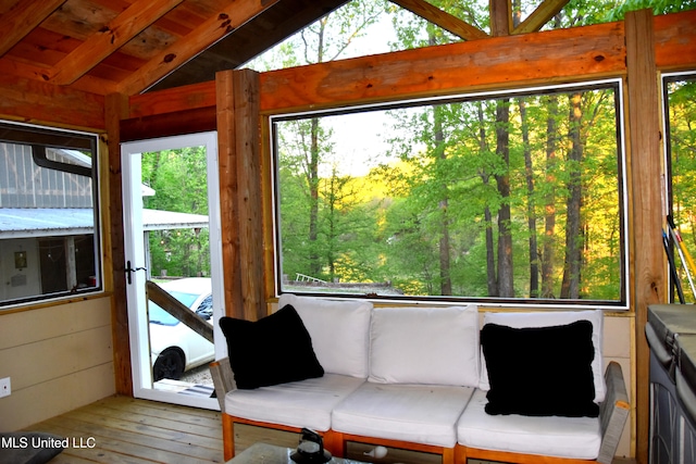 sunroom / solarium featuring beamed ceiling