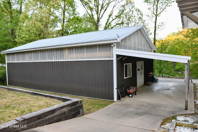 exterior space featuring driveway, metal roof, and a carport