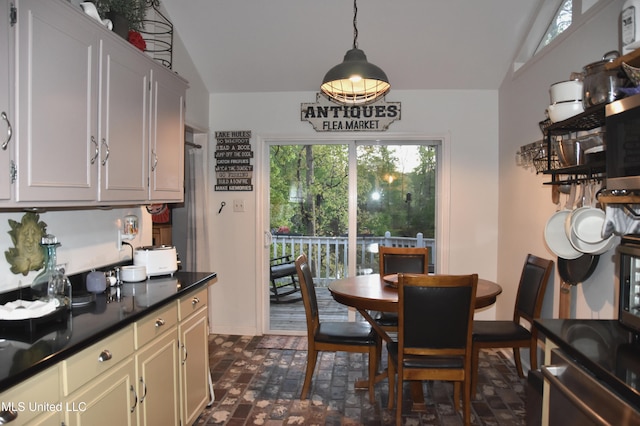 dining room with baseboards, brick floor, and vaulted ceiling