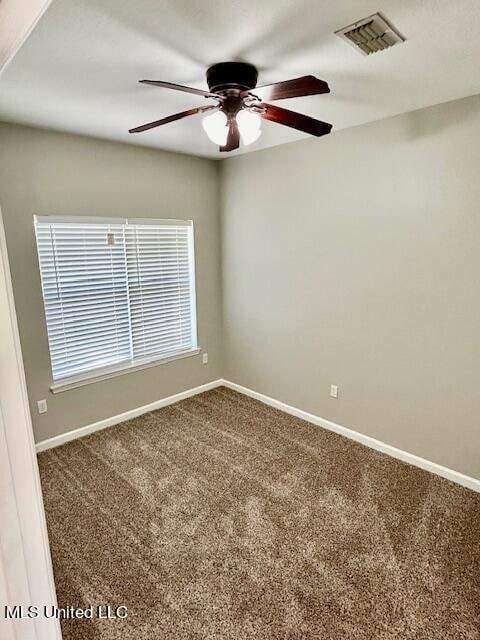 spare room featuring a healthy amount of sunlight, carpet flooring, and ceiling fan