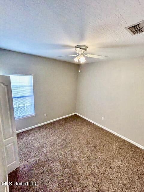 carpeted spare room with ceiling fan and a textured ceiling