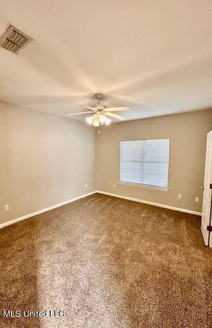 unfurnished room with ceiling fan and dark colored carpet