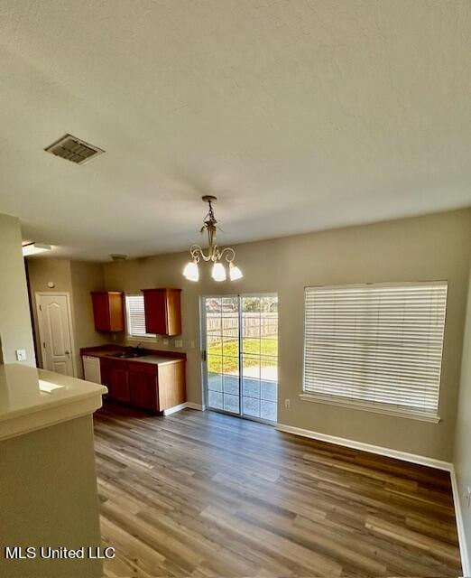 interior space featuring sink, decorative light fixtures, a chandelier, and dark hardwood / wood-style floors