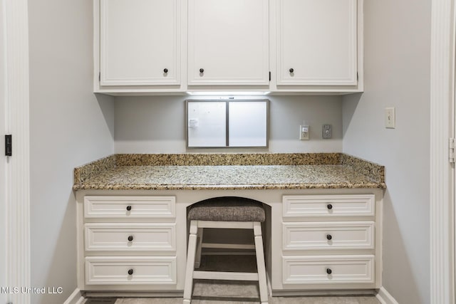 kitchen featuring white cabinetry and light stone counters