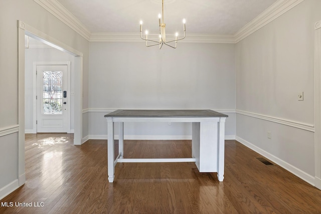 unfurnished dining area featuring dark hardwood / wood-style flooring, crown molding, and a notable chandelier