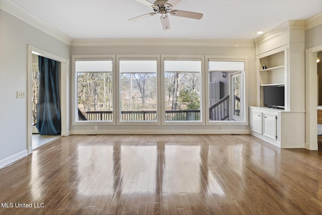 unfurnished living room with hardwood / wood-style flooring, built in features, ceiling fan, and crown molding