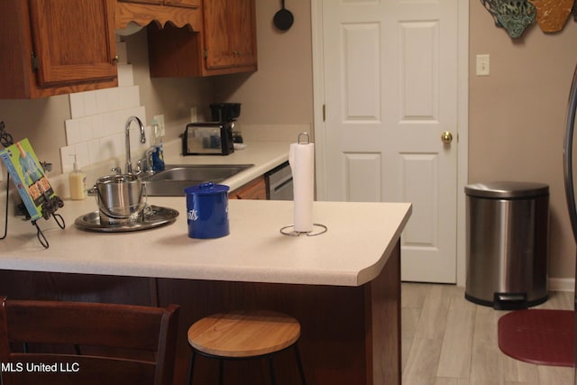 100 Roseleigh Cv, Batesville, MS 38606 - kitchen with light countertops, a kitchen breakfast bar, a peninsula, and brown cabinets