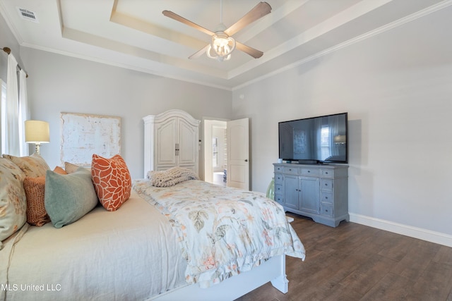 bedroom featuring dark hardwood / wood-style flooring, a tray ceiling, ceiling fan, and crown molding