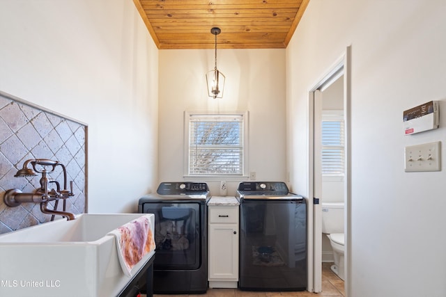 laundry area with wood ceiling, sink, light tile patterned floors, and washing machine and clothes dryer