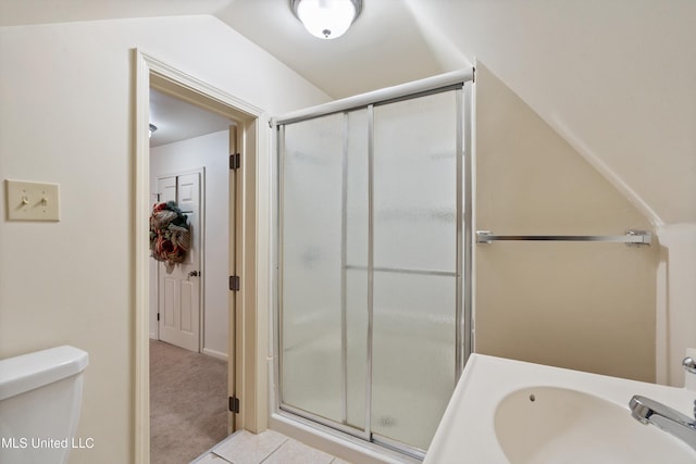 bathroom with sink, tile patterned floors, lofted ceiling, toilet, and a shower with door