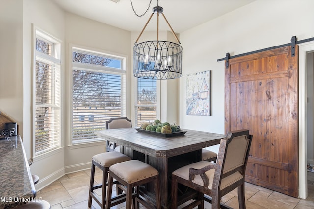 tiled dining room with a chandelier and a barn door