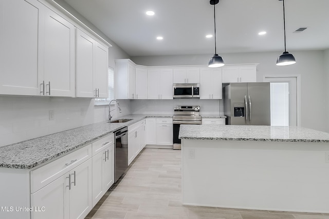 3121 Seahorse Rd, Gautier, MS 39553 - kitchen featuring appliances with stainless steel finishes, a sink, decorative backsplash, white cabinetry, and recessed lighting