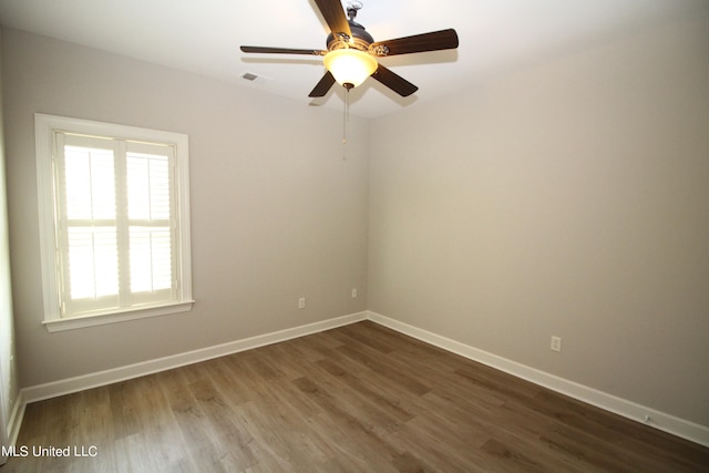 spare room with dark wood-type flooring and ceiling fan