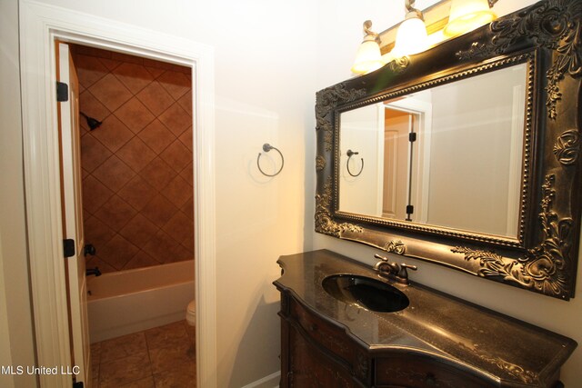 full bathroom with tiled shower / bath, vanity, toilet, and tile patterned flooring