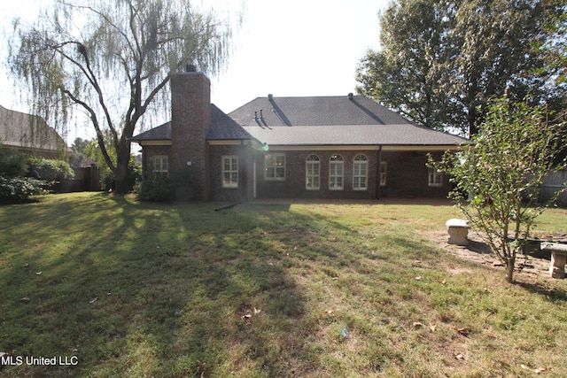 rear view of property featuring a lawn