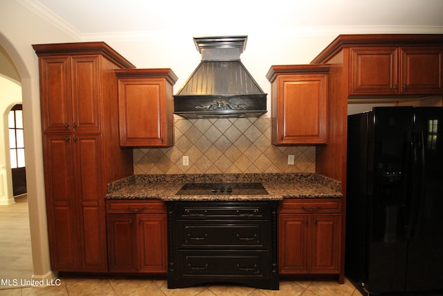 kitchen with premium range hood, black appliances, dark stone counters, and crown molding