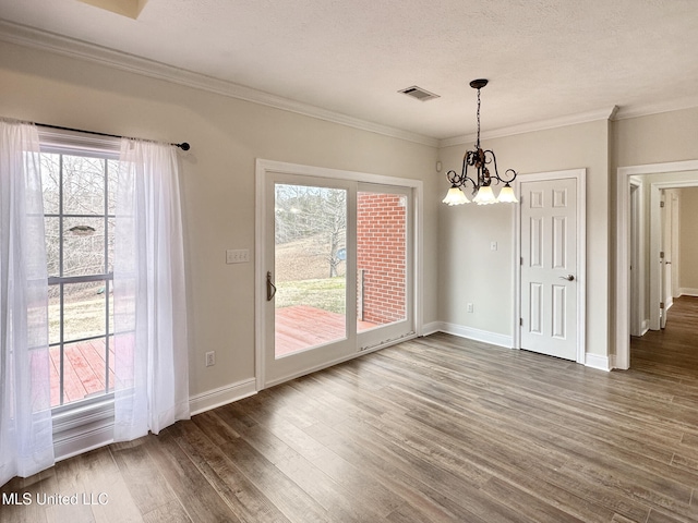 unfurnished dining area featuring crown molding, wood finished floors, visible vents, and a wealth of natural light