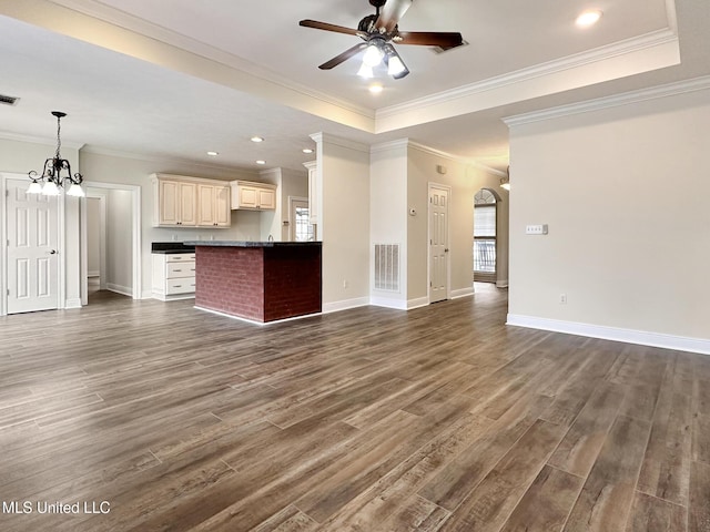 unfurnished living room featuring dark wood-type flooring, ceiling fan with notable chandelier, visible vents, and baseboards