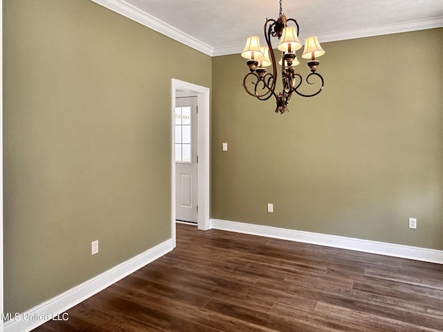 spare room with an inviting chandelier, dark wood-type flooring, crown molding, and baseboards