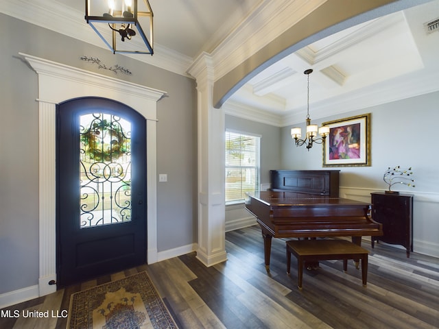 entrance foyer featuring ornamental molding, dark wood-type flooring, a notable chandelier, and coffered ceiling