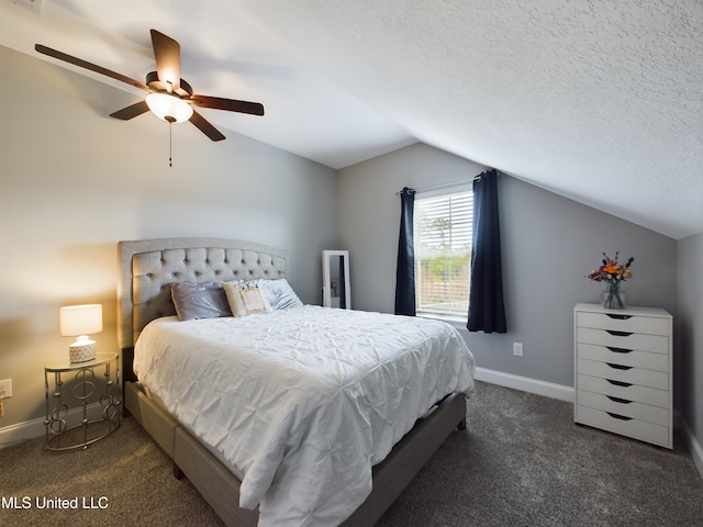 bedroom featuring dark colored carpet, a textured ceiling, vaulted ceiling, and ceiling fan