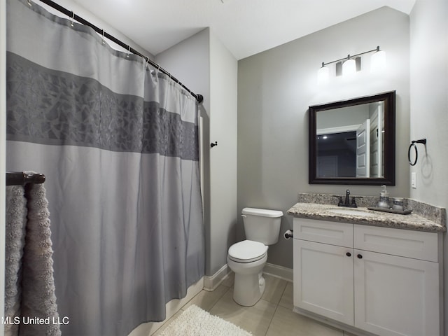 bathroom with tile patterned flooring, vanity, toilet, and walk in shower