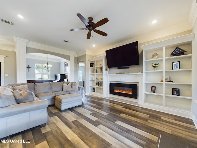 living room with built in shelves, crown molding, dark hardwood / wood-style flooring, and ceiling fan with notable chandelier