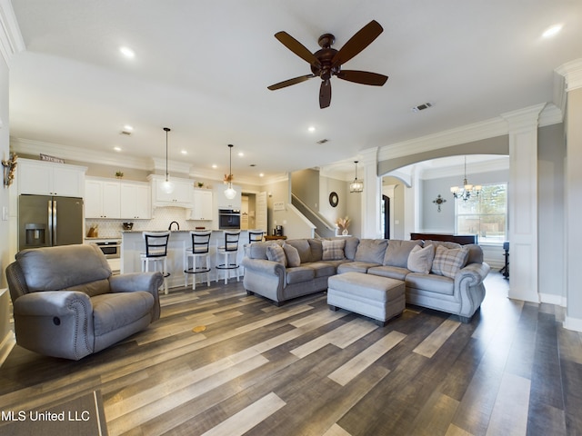 living room with ceiling fan with notable chandelier, dark hardwood / wood-style floors, sink, and crown molding