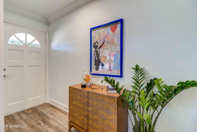 foyer entrance with ornamental molding and light hardwood / wood-style flooring