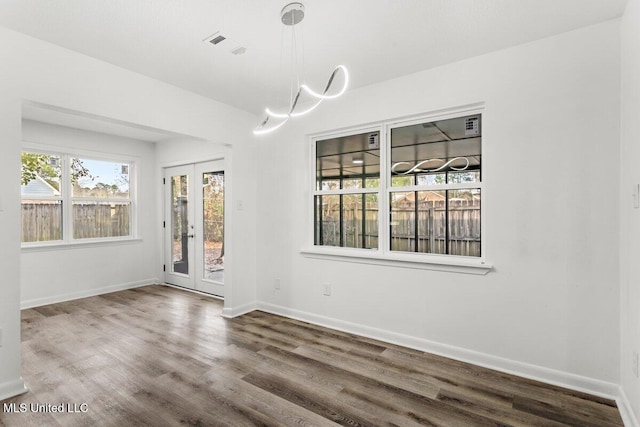 unfurnished dining area featuring hardwood / wood-style flooring and french doors