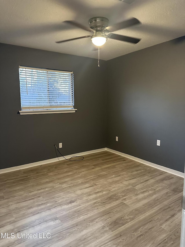 empty room with hardwood / wood-style floors, a textured ceiling, and ceiling fan