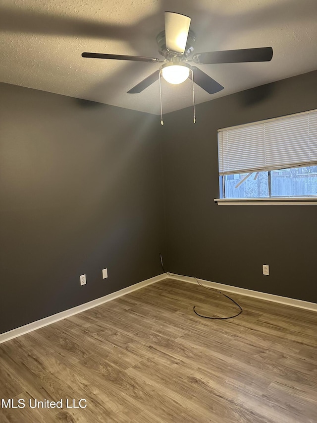 empty room featuring hardwood / wood-style flooring, ceiling fan, and a textured ceiling